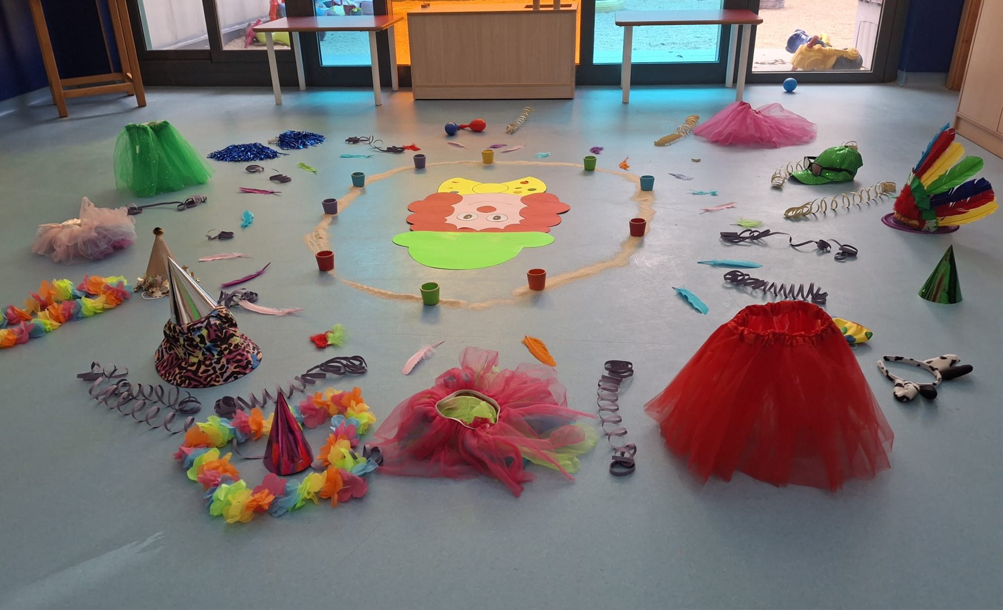Conjunto de materiales de carnaval: cara de payaso, faldas de tul, plumas y collares de flores para niños.