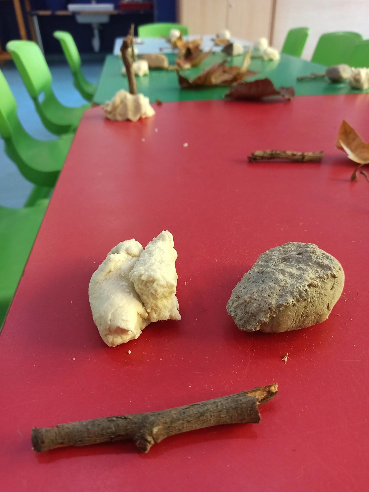 Primer plano de un trozo de pan junto a una piedra y una rama.