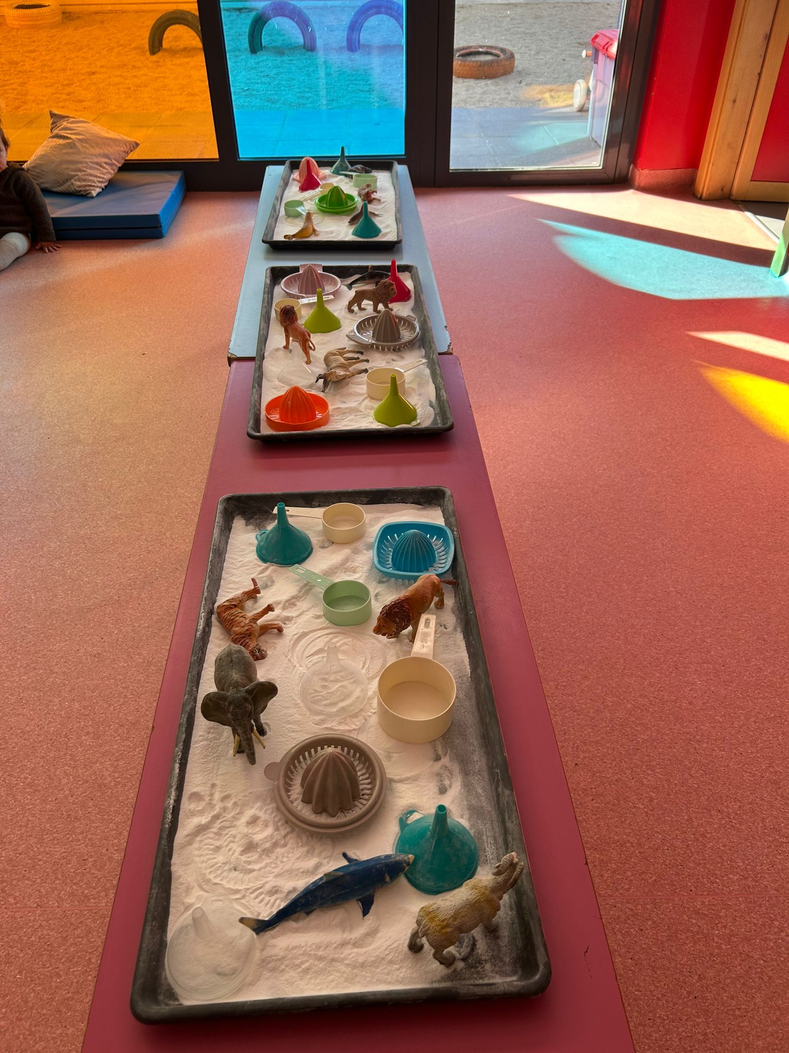 Aula luminosa de la Escuela Infantil El Gato con Botas en Torrejón de Ardoz con estaciones de juego sensorial organizadas.